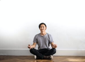 Man sitting on floor meditating