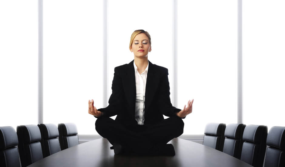 a lady meditating on a conference table
