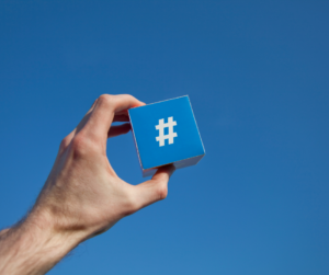 A man holding a hashtag against a blue background
