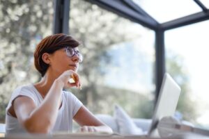 Woman daydreaming at laptop
